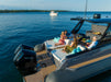 A Zodiac 1100 outboard motor boat on open water with several people relaxing on the rear deck seating. The boat has a gray hull, wood-look flooring, a black hardtop, and black Mercury outboard motors.