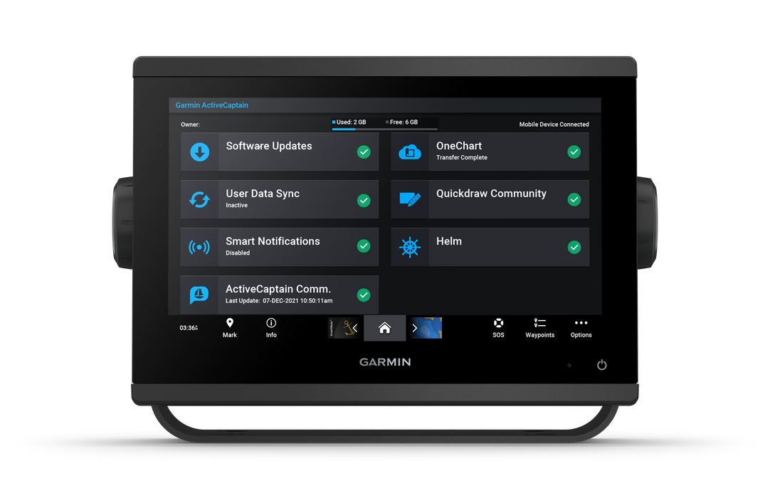 A Garmin handheld touchscreen display device shown front-on against a plain white background. The screen is turned on and displays a dark blue and black user interface with various app tiles such as Software Updates, OneChart, and Helm.