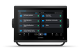 A Garmin handheld touchscreen display device shown front-on against a plain white background. The screen is turned on and displays a dark blue and black user interface with various app tiles such as Software Updates, OneChart, and Helm.