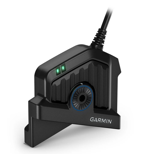 A black Garmin electronic device with a cable connector, featuring a ribbed textured body, a circular blue-accented lens, two green indicator lights, and the GARMIN logo printed on the front, set against a plain white background.